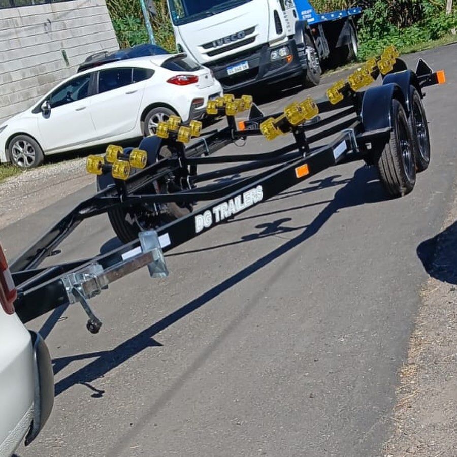 Tráiler negro de un eje con rolos amarillos